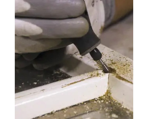 Remeselník opracováva drevo multifunkčným nástrojom