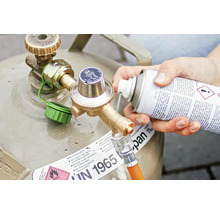 Osoba strieka čistiaci prostriedok na pripojenie plynovej fľaše