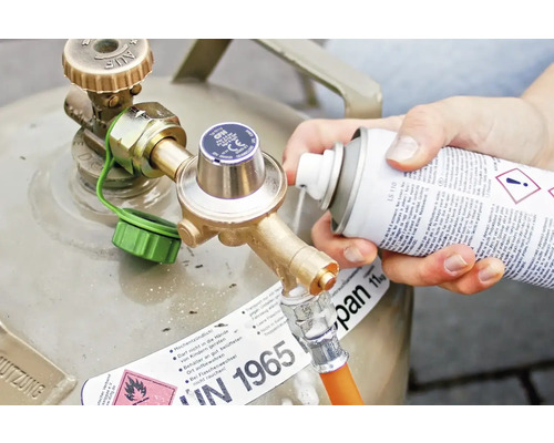 Osoba strieka čistiaci prostriedok na pripojenie plynovej fľaše