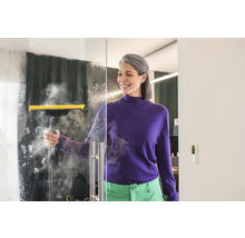 Žena čistí sklenenú stenu parným čističom