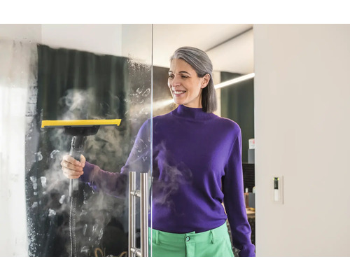 Žena čistí sklenenú stenu parným čističom