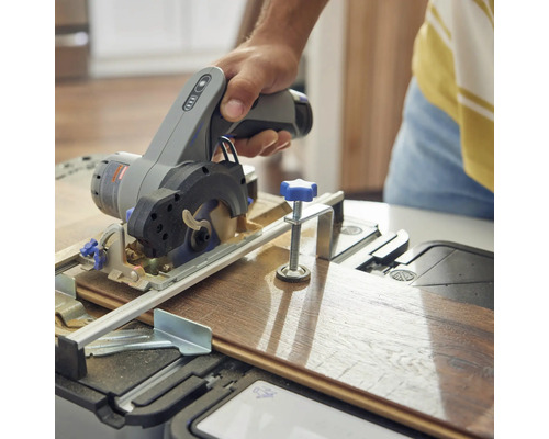 Osoba reže drevenú dosku ručnou kotúčovou pílou.