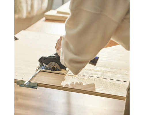 Osoba reže drevo kotúčovou pílou.