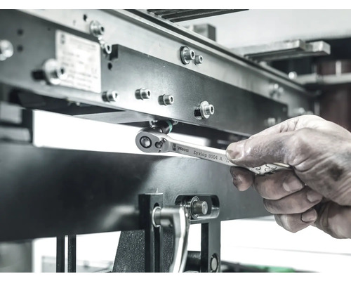 Pracovník uťahuje skrutku na kovovej konštrukcii pomocou očkového kľúča Wera Zyklop 8004 A.