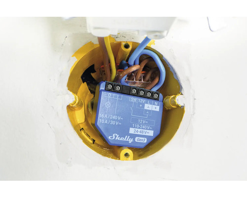 Elektrický spínač v žltej spojovacej krabici s káblami