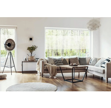 Obývacia izba s pohovkou, vankúšmi, konferenčným stolíkom, stojacou lampou a oknom