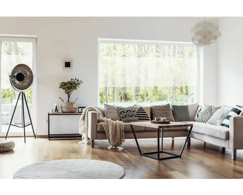 Obývacia izba s pohovkou, vankúšmi, konferenčným stolíkom, stojacou lampou a oknom