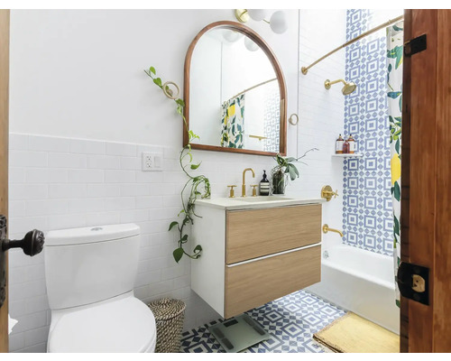 Kúpeľňa s toaletou, umývadlovou skrinkou, zrkadlom a vaňou so sprchovým závesom