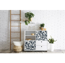 Pohľad do izby s bielou úložnou skriňou, rebríkom a izbovými rastlinami pred bielou tehlovou stenou