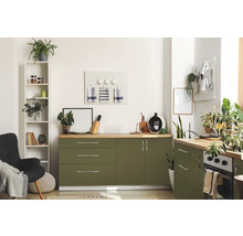 Svetlá kuchyňa so zelenými skrinkami, drevenými pracovnými doskami a rôznymi dekoratívnymi predmetmi