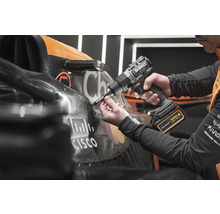 Mechanik upevňuje diel na pretekárske auto pomocou akumulátorového skrutkovača.