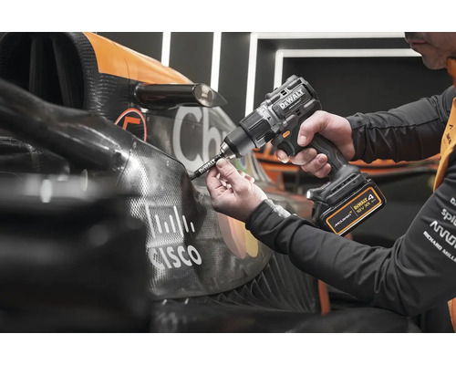 Mechanik upevňuje diel na pretekárske auto pomocou akumulátorového skrutkovača.