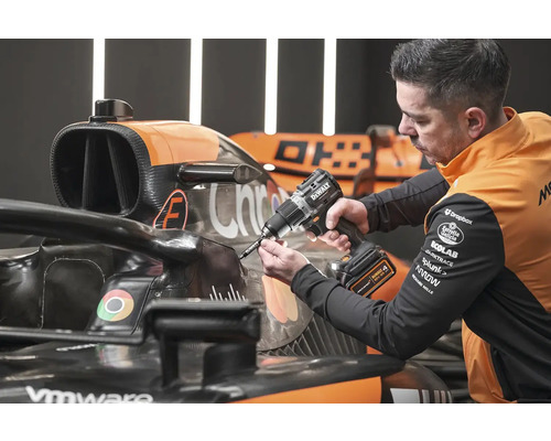 Mechanik používa akumulátorový vŕtací skrutkovač DeWalt na závodnom aute.