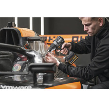 Muž používa akumulátorový vŕtací skrutkovač DeWalt na pretekárskom vozidle Formuly 1.