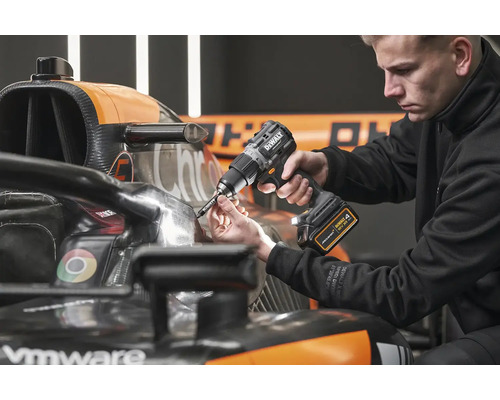 Muž používa akumulátorový vŕtací skrutkovač DeWalt na pretekárskom vozidle Formuly 1.