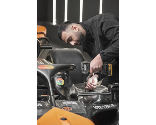 Muž používa akumulátorový vŕtací skrutkovač DeWalt na vozidle Formuly 1.
