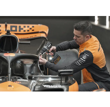 Mechanik používa akumulátorový skrutkovač na prácu na pretekárskom aute Formuly 1.