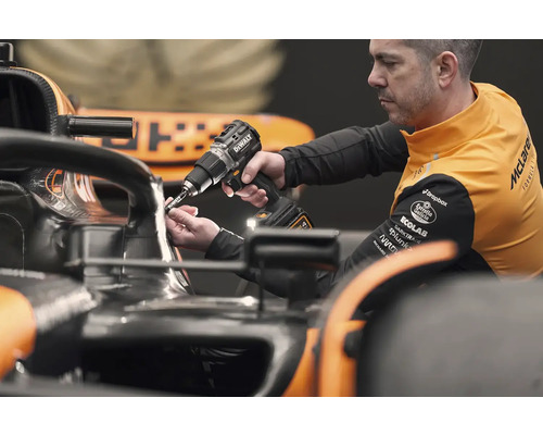 Mechanik používa akumulátorový skrutkovač DeWalt na závodnom aute.