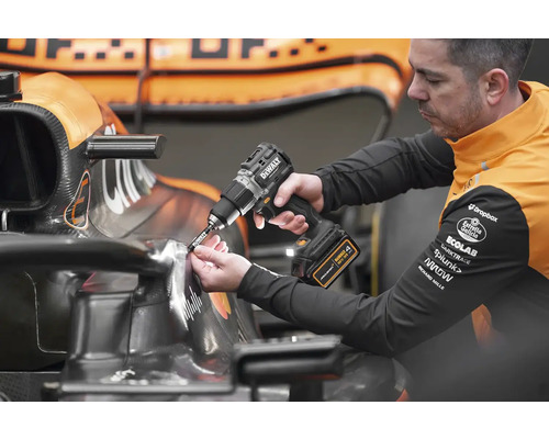 Muž používa akumulátorový skrutkovač na pretekárskom aute.