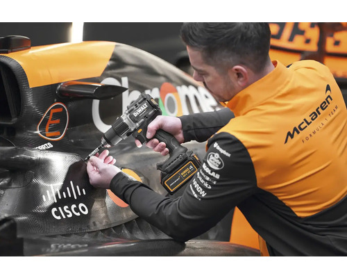 Mechanik používa akumulátorový vŕtací skrutkovač DeWalt na závodnom aute.
