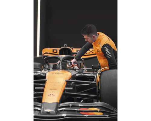 Mechanik pracuje s akumulátorovým skrutkovačom na pretekárskom aute.