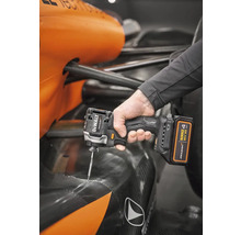 Muž používa akumulátorový rázový uťahovák DeWalt na vozidle formuly 1 McLaren.