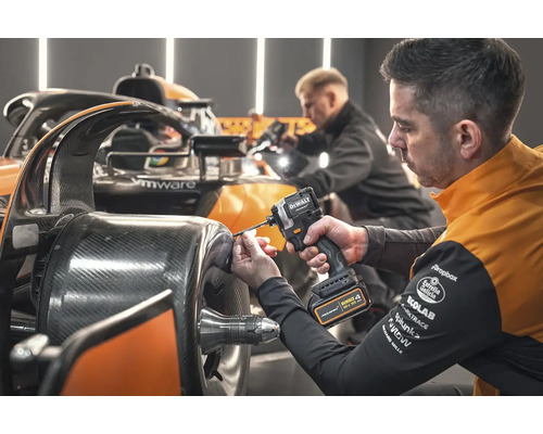 Mechanik pripevňuje diel k závodnému autu pomocou akumulátorového rázového uťahováka DeWalt.