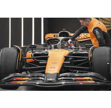 Mechanik pracuje s akumulátorovým skrutkovačom na závodnom vozidle Formuly 1.