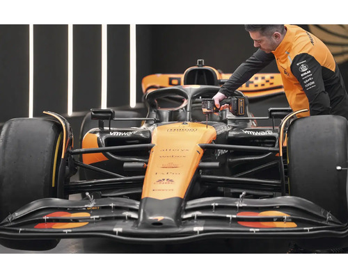 Mechanik pracuje s akumulátorovým skrutkovačom na závodnom vozidle Formuly 1.