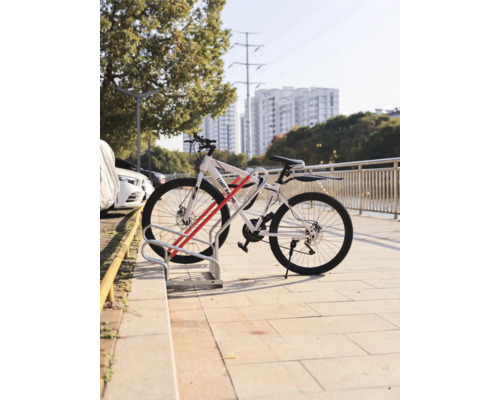 Bicykel zaparkovaný v stojane na bicykle pred mestským pozadím