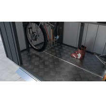 Vnútorný pohľad na záhradný domček s bicyklom, náradím a gumákmi na podlahe