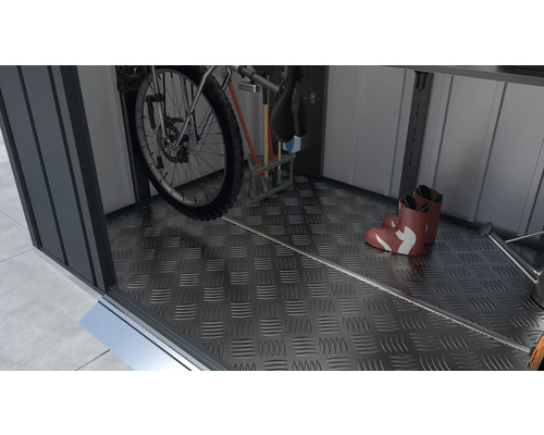 Interiér kôlne na náradie s bicyklom, záhradným náradím a gumákmi na podlahe z vlnitého plechu