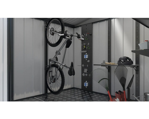 Bicykel na nástennom držiaku v kôlni na náradie spolu s náradím a záhradným náradím