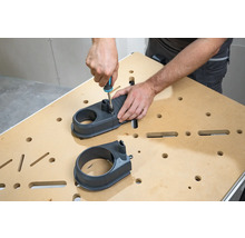 Osoba montuje odsávací nadstavec pomocou skrutkovača na pracovný stôl