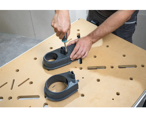 Osoba montuje odsávací nadstavec pomocou skrutkovača na pracovný stôl