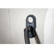 Zásuvka na pripojenie vysávača s pripojenou hadicou vysávača na stene