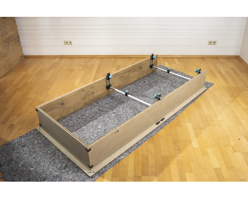 Montáž dreveného rámu s upínacími prípravkami na ochrannej podložke