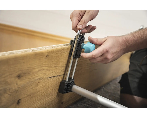 Používateľ upevňuje drevenú dosku montážnym nástrojom.