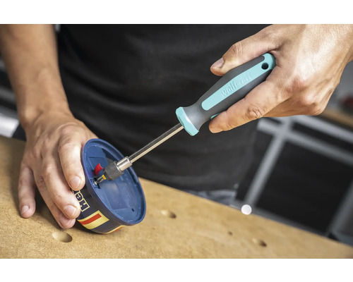 Osoba používa skrutkovač na utiahnutie skrutky.