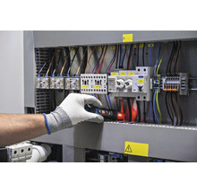 Elektrikár kontroluje rozvádzač pomocou skúšačky napätia