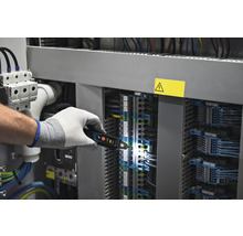 Elektrikár kontroluje rozvádzač pomocou skúšačky napätia