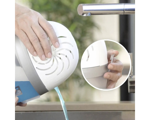 Osoba vylieva vodu z odvlhčovača vzduchu do umývadla.