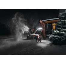 Osoba používa snehovú frézu na odpratávanie snehu.