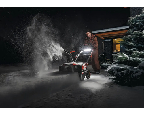 Osoba používa snehovú frézu na odpratávanie snehu.