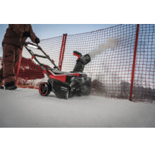 Osoba obsluhuje snehovú frézu na odpratávanie snehu.