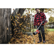 Muž s akumulátorovým fúkačom lístia v záhrade fúka lístie