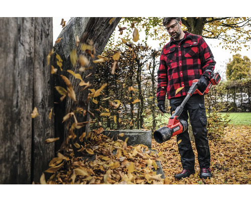 Muž s akumulátorovým fúkačom lístia v záhrade fúka lístie