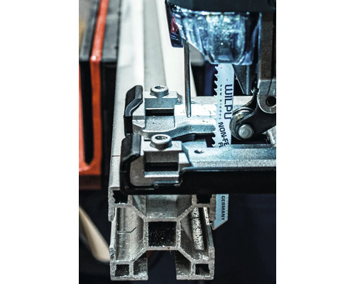 Detailný pohľad na priamočiaru pílu reznúcu kovový profil.