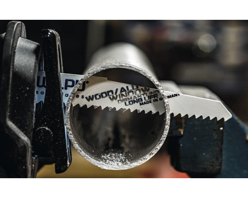 Pílový list na kov reže kovovú rúrku v držiaku