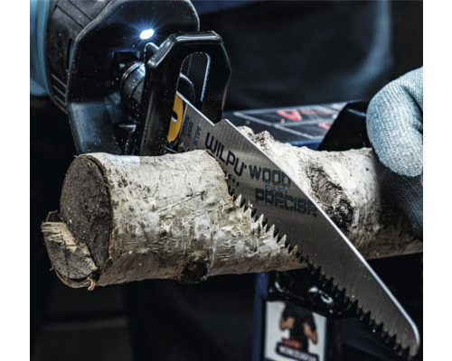 Detailný pohľad na chvostovú pílu reznúcu kus dreva.